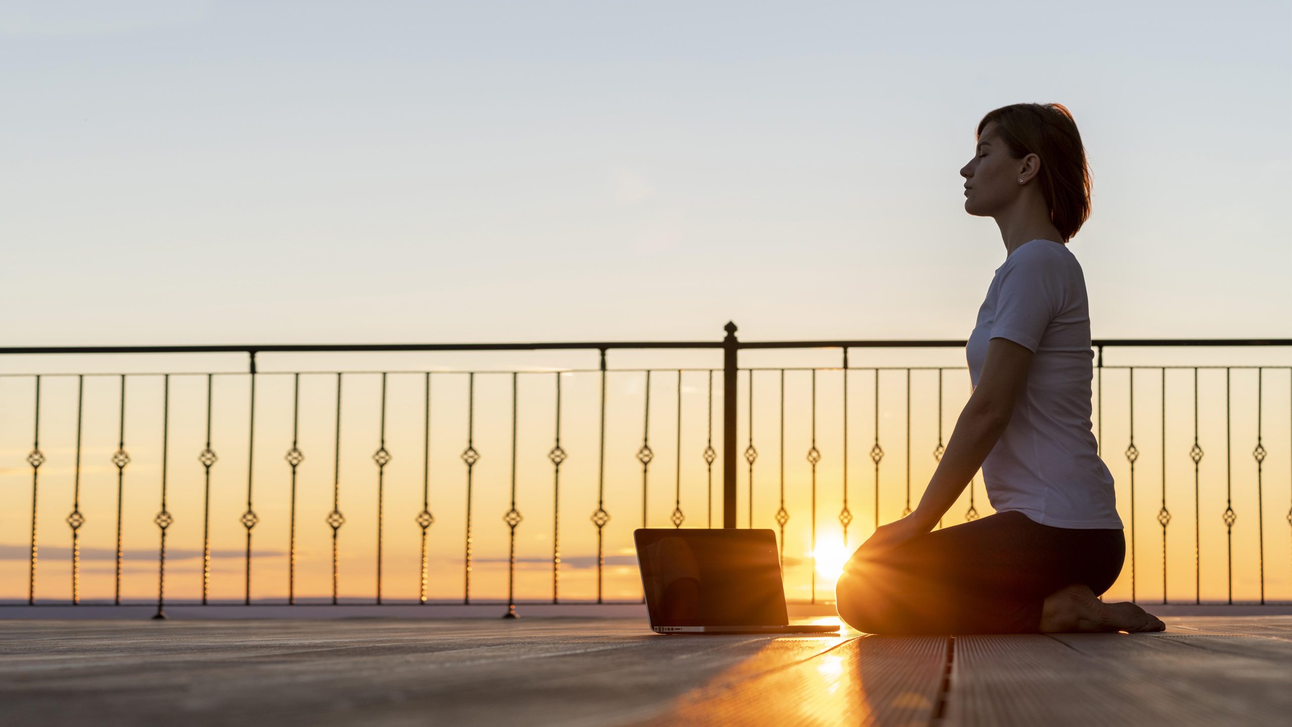 full shot woman with laptop meditating